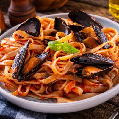 A plate of delicious mussels with marinara tomato sauce and fettuccine.